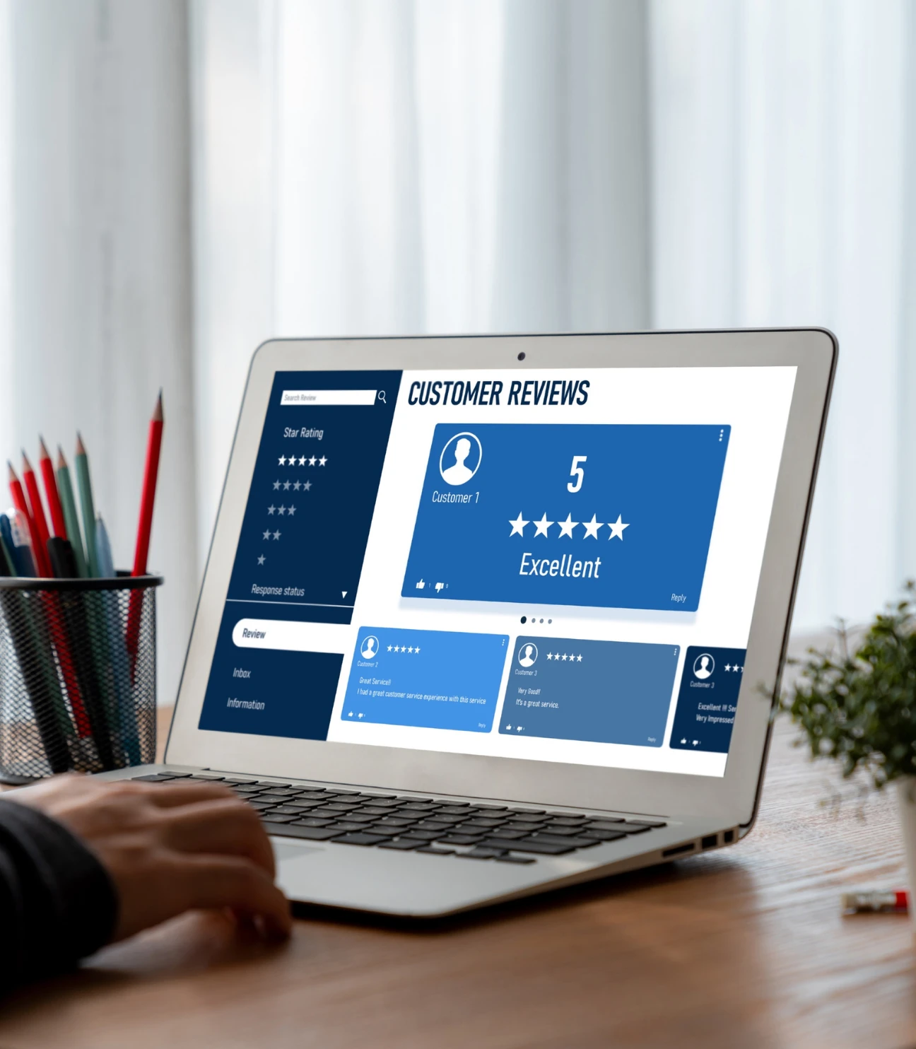 A person reviewing customer ratings on a laptop. The screen displays a customer review interface with star ratings, comments, and a five-star rating for 'Customer 1' marked as 'Excellent'. A colorful pen holder and stationery are visible in the background.