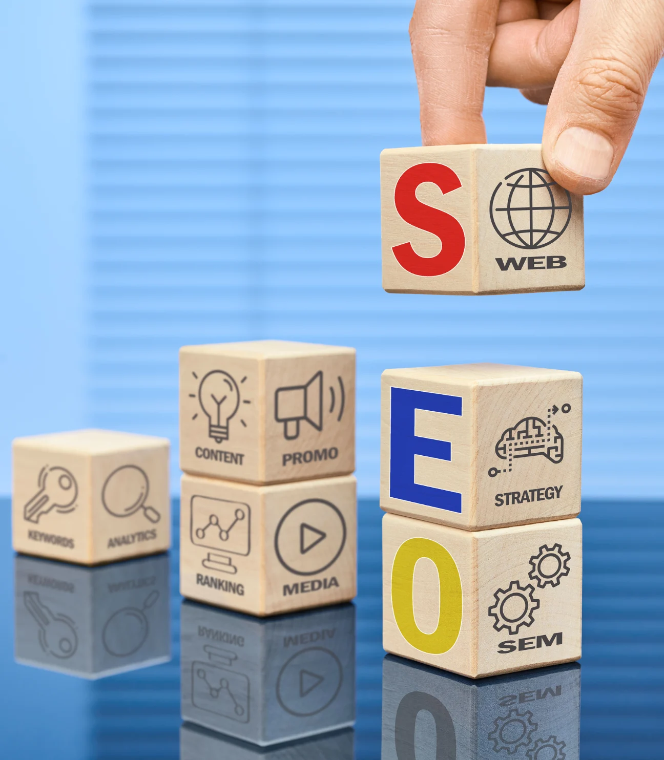 A hand placing the 'S' block on top of other blocks with SEO-related terms like 'Content,' 'Promo,' 'Keywords,' 'Ranking,' and 'Analytics,' visually representing SEO link building concepts.
