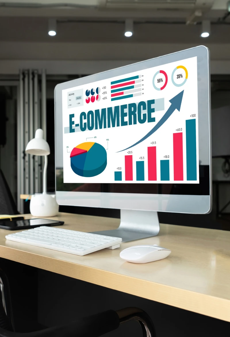 A desktop computer displaying colorful graphs and charts related to eCommerce growth, including pie charts and bar graphs. The screen showcases data relevant to eCommerce SEO Services, with an upward arrow indicating progress, set on a modern desk with a keyboard and mouse.